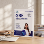 A GRE Analytical Writing test prep book stands upright on a wooden desk, surrounded by notebooks, a pen, and eyeglasses in a softly lit study setting. 